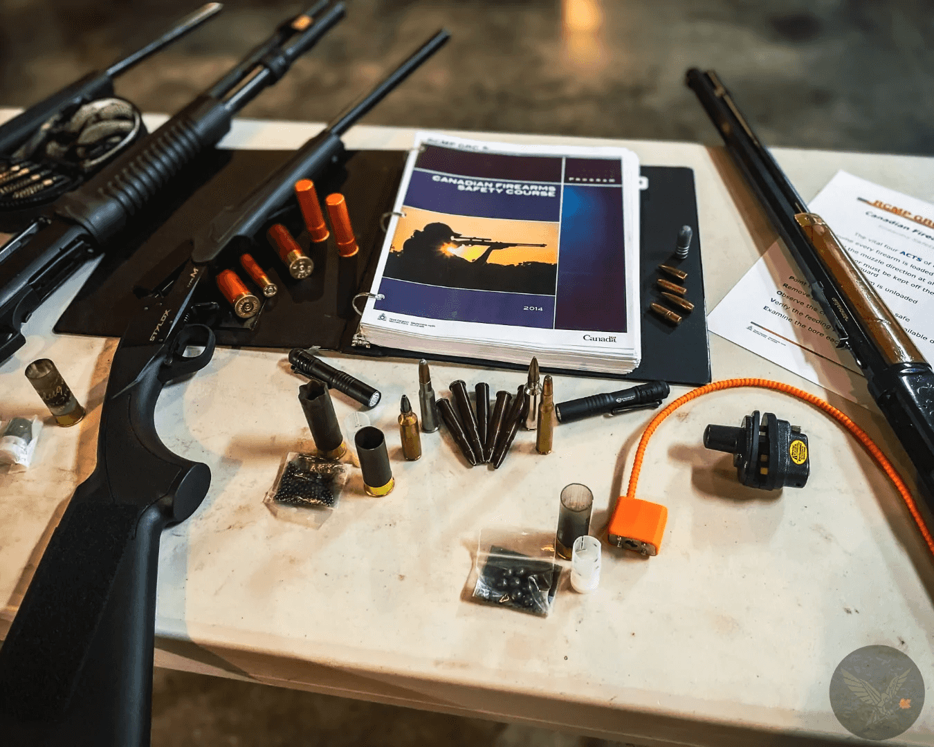 Disabled training firearms, inert ammunition and the CFSC handbook laid out on a classroom table