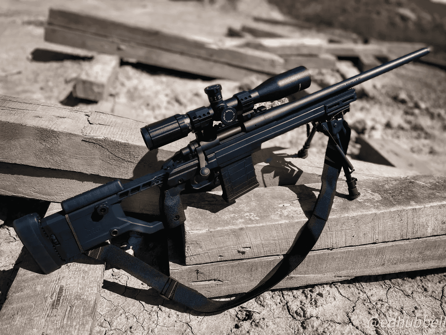 Bolt-action rifle with scope resting on weathered timber