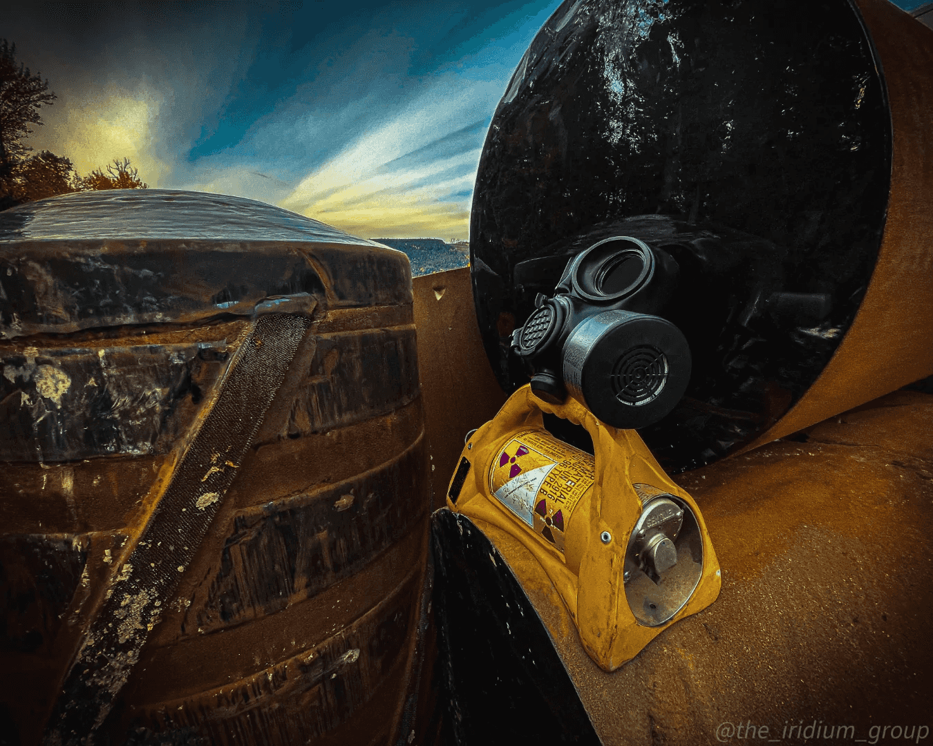 Gas mask and radiation survey meter resting on a rusted vehicle at dusk