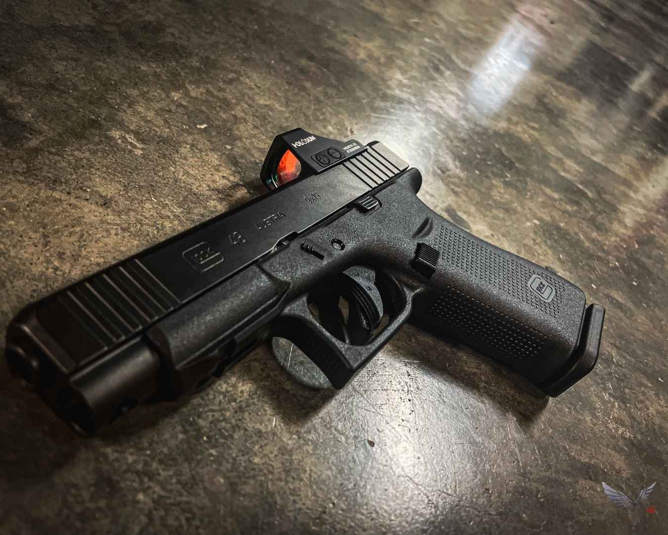 Handgun with optic resting on a textured surface