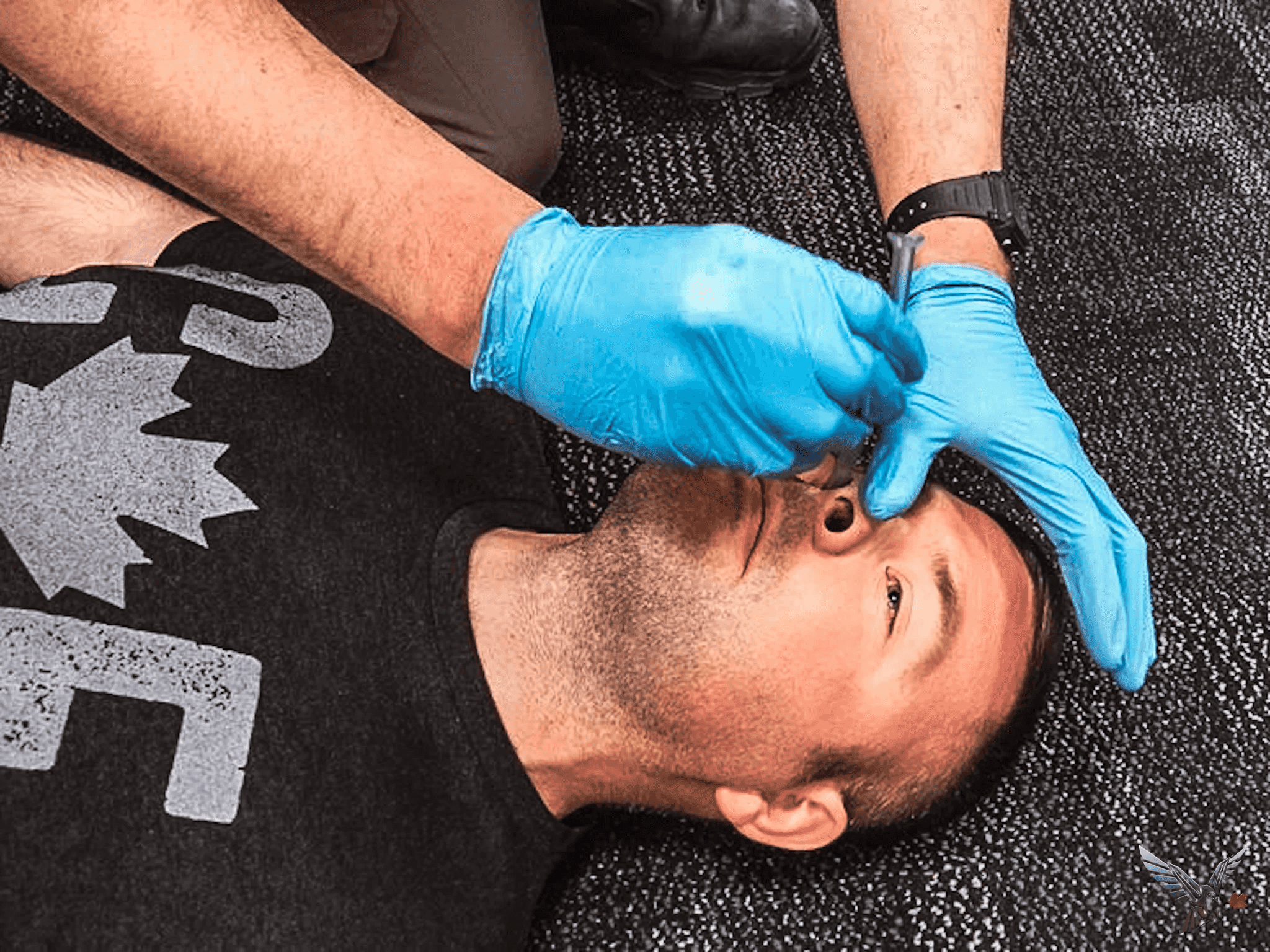 Gloved hands inserting a nasopharyngeal airway on a student